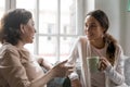 Loving 50s old woman sharing life news with grown daughter.