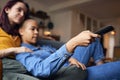 Loving Same Sex Female Couple Lying On Sofa At Home Watching TV And Relaxing Together Royalty Free Stock Photo