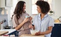 Loving Same Sex Female Couple Wearing Pyjamas Making Morning Pancakes In Kitchen At Home