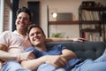 Loving Same Sex Male Couple Lying On Sofa At Home Watching TV And Relaxing Together Royalty Free Stock Photo