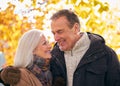 Loving Senior Couple Hugging As They Walk Along Autumn Woodland Path Through Trees Royalty Free Stock Photo