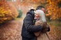Loving Senior Couple Hugging As They Walk Along Autumn Woodland Path Through Trees Royalty Free Stock Photo