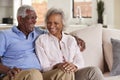 Loving Senior Couple Sitting On Sofa At Home And Laughing Together Royalty Free Stock Photo