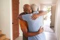 Loving Senior Father Hugging Adult Son Indoors At Home