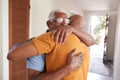 Loving Senior Father Hugging Adult Son Indoors At Home