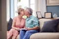 Loving Senior Retired Couple Sitting On Sofa At Home Enjoying Looking Through Family Photo Album Royalty Free Stock Photo