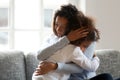 Loving single black mother hugging african daughter caressing cu