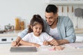 Loving single father and daughter painting together at kitchen Royalty Free Stock Photo