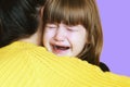 A loving sister hugging a sad, crying child. A little girl is crying on her sister`s shoulder. mom hugs a frustrated child. A youn Royalty Free Stock Photo