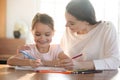 Loving smiling mother and little daughter drawing colorful pencils Royalty Free Stock Photo