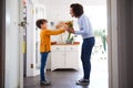 Loving Son Giving Mother Bunch Of Flowers To Celebrate Mothers Day At Home Royalty Free Stock Photo