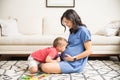 Son Kissing Abdomen Of Pregnant Mom In Living Room Royalty Free Stock Photo