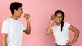 Loving teen couple talking through tin can phone