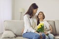 Loving teen girl congratulate mom presenting bouquet