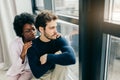 Romantic mixed race couple standing by the window thinking about their future. Royalty Free Stock Photo