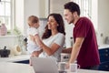 Loving Transgender Family With Baby At Home Together Looking At Laptop On Kitchen Counter Royalty Free Stock Photo