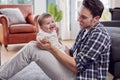 Loving Transgender Father Playing With Baby Son Sitting On Floor At Home