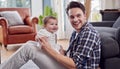 Loving Transgender Father Playing With Baby Son Sitting On Floor At Home