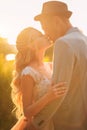 Loving wedding couple hugs and kisses in the summer at sunset. The concept of romantic relationship, idyll. Close-up kiss and tend