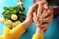 Loving young couple with beautiful pendant on color table, closeup