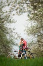 Loving young couple with bicycles in spring garden Royalty Free Stock Photo