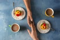 Loving young couple with coffee and desserts on color table Royalty Free Stock Photo