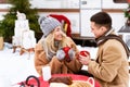 Loving Young Couple Drinking Hot Chocolate While Sitting Outdoors At Winter Campsite Royalty Free Stock Photo