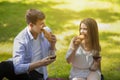 Loving young couple eating croissants and drinking wine on picnic at park Royalty Free Stock Photo