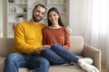 Loving Young Couple Embracing While Sitting On Sofa At Home Royalty Free Stock Photo
