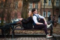 Loving young couple, guy and girl sitting on bench in city park Royalty Free Stock Photo