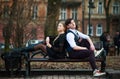 Loving young couple, guy and girl sitting on bench in city park Royalty Free Stock Photo