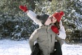 Loving young couple is having fun in winter outdoors. Guy rolls girl on his back Royalty Free Stock Photo