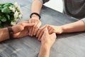 Loving young couple holding hands on grey table, closeup Royalty Free Stock Photo