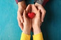 Loving young couple holding red heart on color background Royalty Free Stock Photo