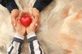 Loving young couple holding red heart on color background Royalty Free Stock Photo