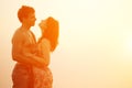 A loving young couple hugging and kissing on the beach at sunset Royalty Free Stock Photo