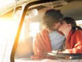 Loving young couple kissing in campervan during roadtrip Royalty Free Stock Photo