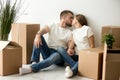 Loving young couple kissing, holding hands in new apartment