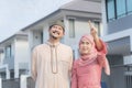 Loving young couple looking at dream house. Portrait of an excited Muslim couple standing outside their new home, walking on the Royalty Free Stock Photo