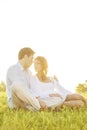 Loving young couple looking at each other on grass against clear sky Royalty Free Stock Photo