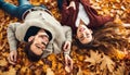 A loving young couple lying on autumn leaves, enjoying a beautifu