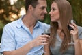 Loving young couple with red wine looking at each other in park Royalty Free Stock Photo