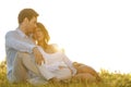 Loving young couple sitting on grass against clear sky Royalty Free Stock Photo