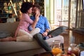 Loving couple sitting together on sofa and kissing Royalty Free Stock Photo