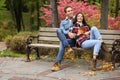 Loving young couple sitting on wooden bench in autumn park Royalty Free Stock Photo