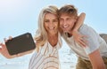 Loving young couple taking selfie with phone while enjoying a day at the beach smiling and hugging. Romantic husband and Royalty Free Stock Photo