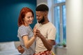 Loving young diverse couple dancing romantic dance in modern bedroom with panoramic windows. Royalty Free Stock Photo