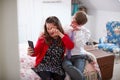 Loving Young Downs Syndrome Couple Sitting On Bed Using Mobile Phone To Take Selfie At Home Royalty Free Stock Photo