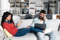 Loving young happy couple using laptop and analyzing their finances, writing notes, man with computer woman with notebook Royalty Free Stock Photo