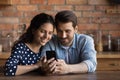 Loving young husband and wife embrace watch video on cellphone Royalty Free Stock Photo